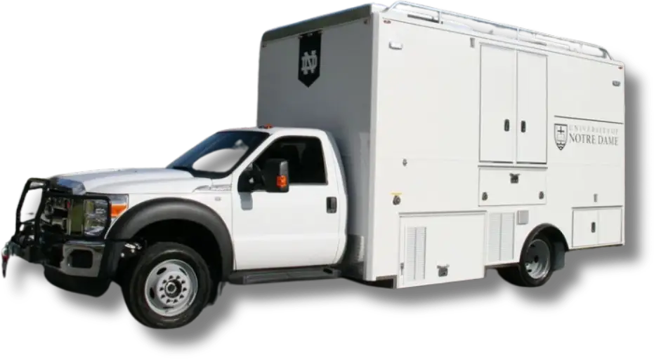 A large white utility truck with University of Notre Dame logos on the side and rear. The truck features several storage compartments, equipment access panels, and a shiny grille on the front cab, representing Notre Dame with pride.